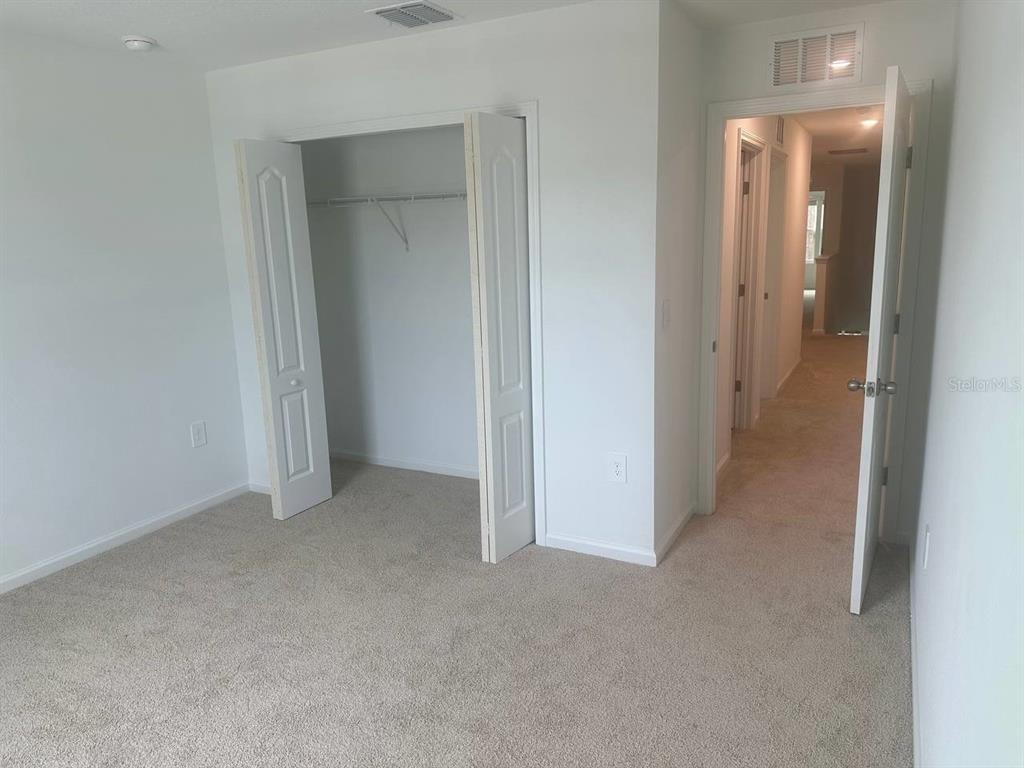 455 Redbud Road Palm Coast, FL 32137 - Photo 7 of 12 an empty room with closet and a bathroom