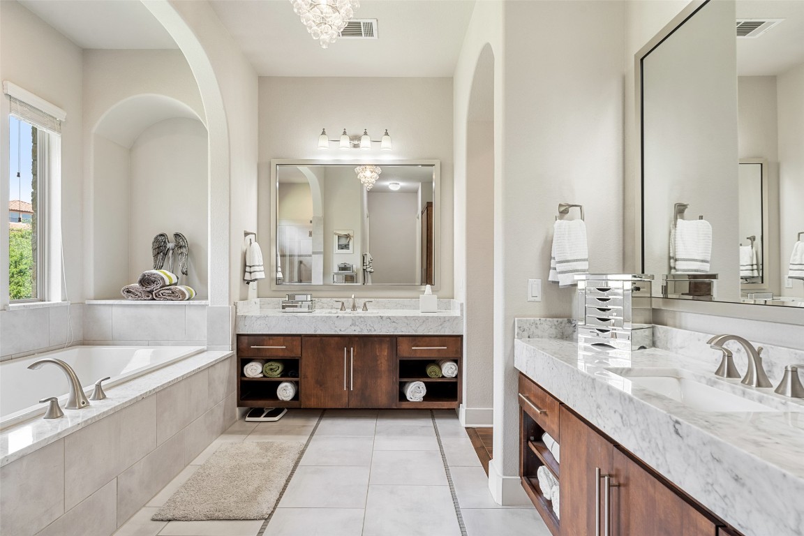 13009 Zen Gardens Way Austin, TX 78732 - Photo 22 of 40 a spacious bathroom with a tub double sink and mirror