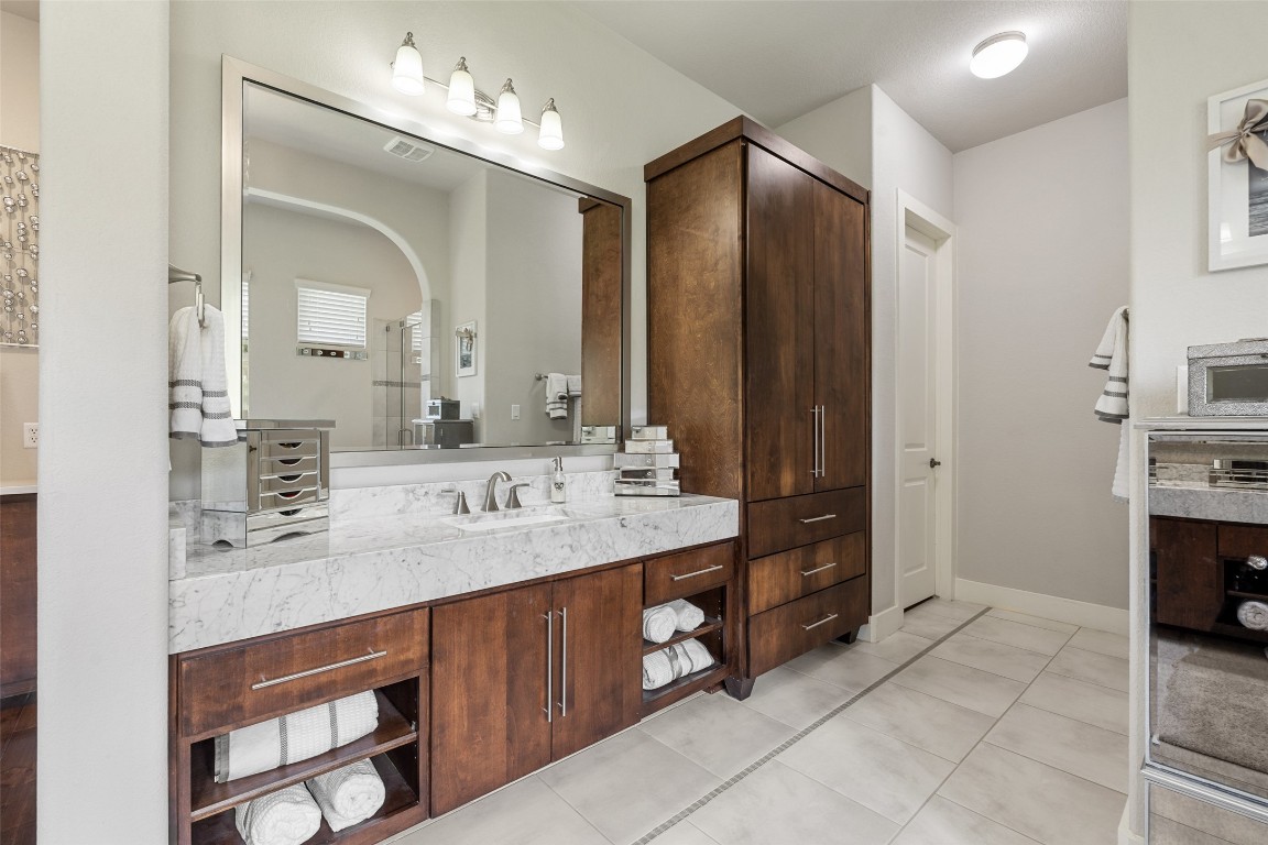13009 Zen Gardens Way Austin, TX 78732 - Photo 23 of 40 a bathroom with a double vanity sink and a mirror