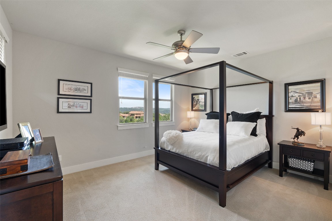 13009 Zen Gardens Way Austin, TX 78732 - Photo 29 of 40 a bedroom with a bed lamp on desk and a window
