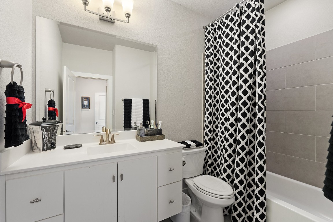 13009 Zen Gardens Way Austin, TX 78732 - Photo 30 of 40 a bathroom with a sink a toilet and a mirror