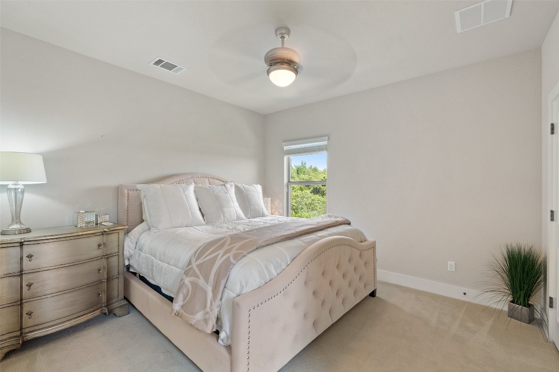 13009 Zen Gardens Way Austin, TX 78732 - Photo 33 of 40 a bedroom with a bed and a lamp
