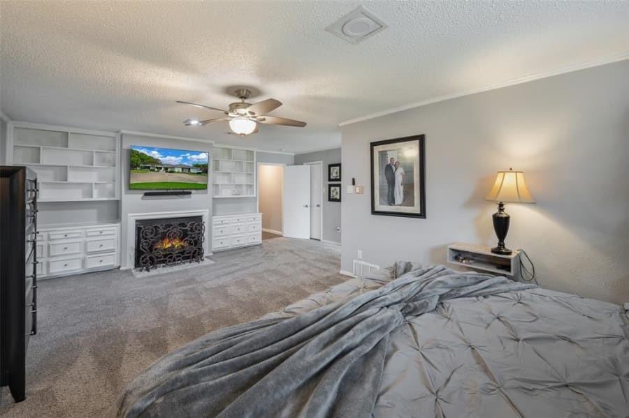 8 Canyon Ridge Drive Fate, TX 75087 - Photo 18 of 40 a bedroom with a bed and a fireplace