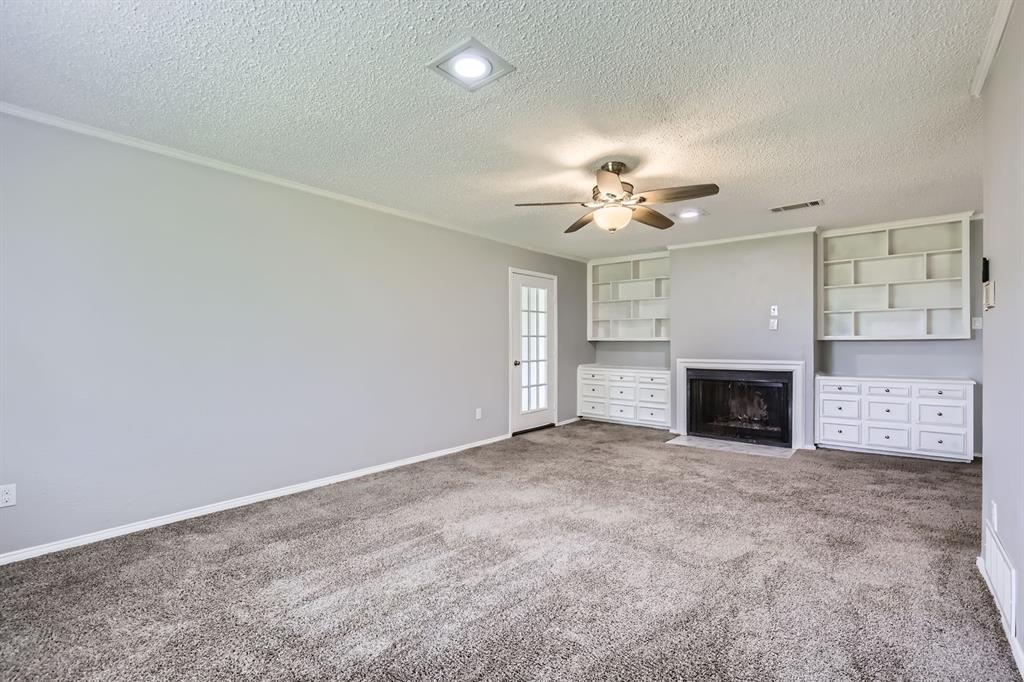 8 Canyon Ridge Drive Fate, TX 75087 - Photo 21 of 40 an empty room with a fireplace and a ceiling fan