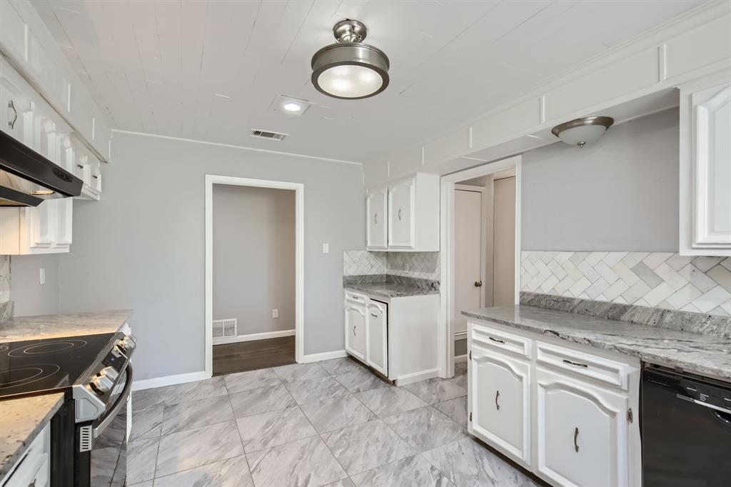 8 Canyon Ridge Drive Fate, TX 75087 - Photo 22 of 40 a kitchen with granite countertop a sink cabinets stainless steel appliances and a rug