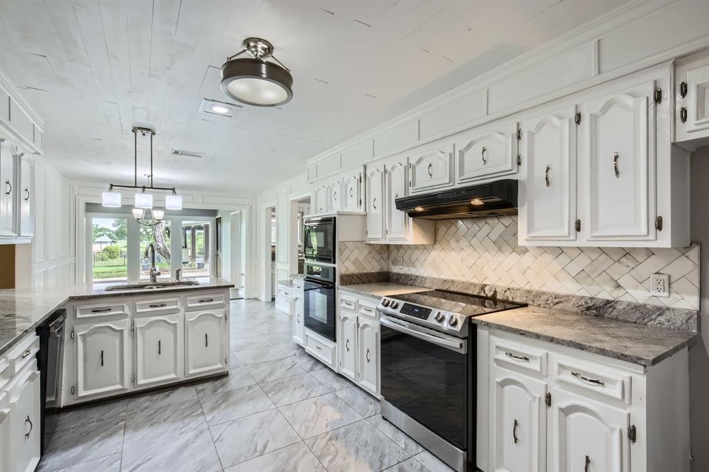 8 Canyon Ridge Drive Fate, TX 75087 - Photo 23 of 40 a kitchen with stainless steel appliances granite countertop a stove sink and cabinets