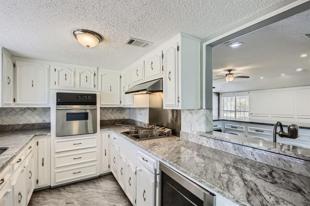 8 Canyon Ridge Drive Fate, TX 75087 - Photo 24 of 40 a kitchen with granite countertop a stove sink and cabinets