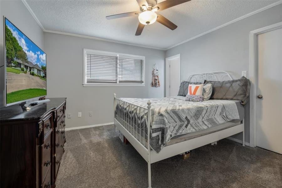 8 Canyon Ridge Drive Fate, TX 75087 - Photo 29 of 40 a bedroom with a bed and a flat tv screen on the dresser