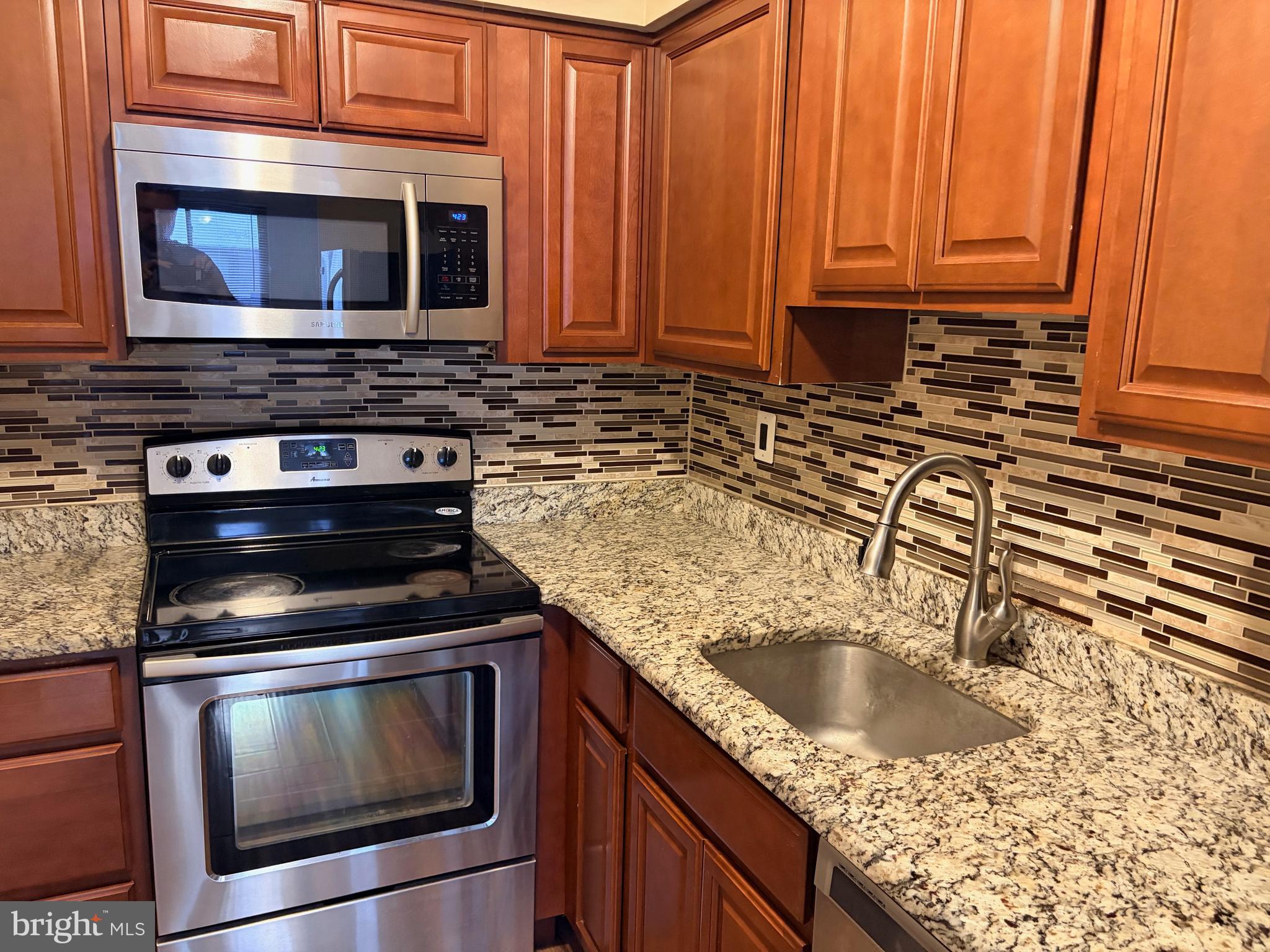 2036 Jason Drive, Unit A Huntingdon Valley, PA 19006 - Photo 4 of 10 a kitchen with granite countertop a sink stove and microwave