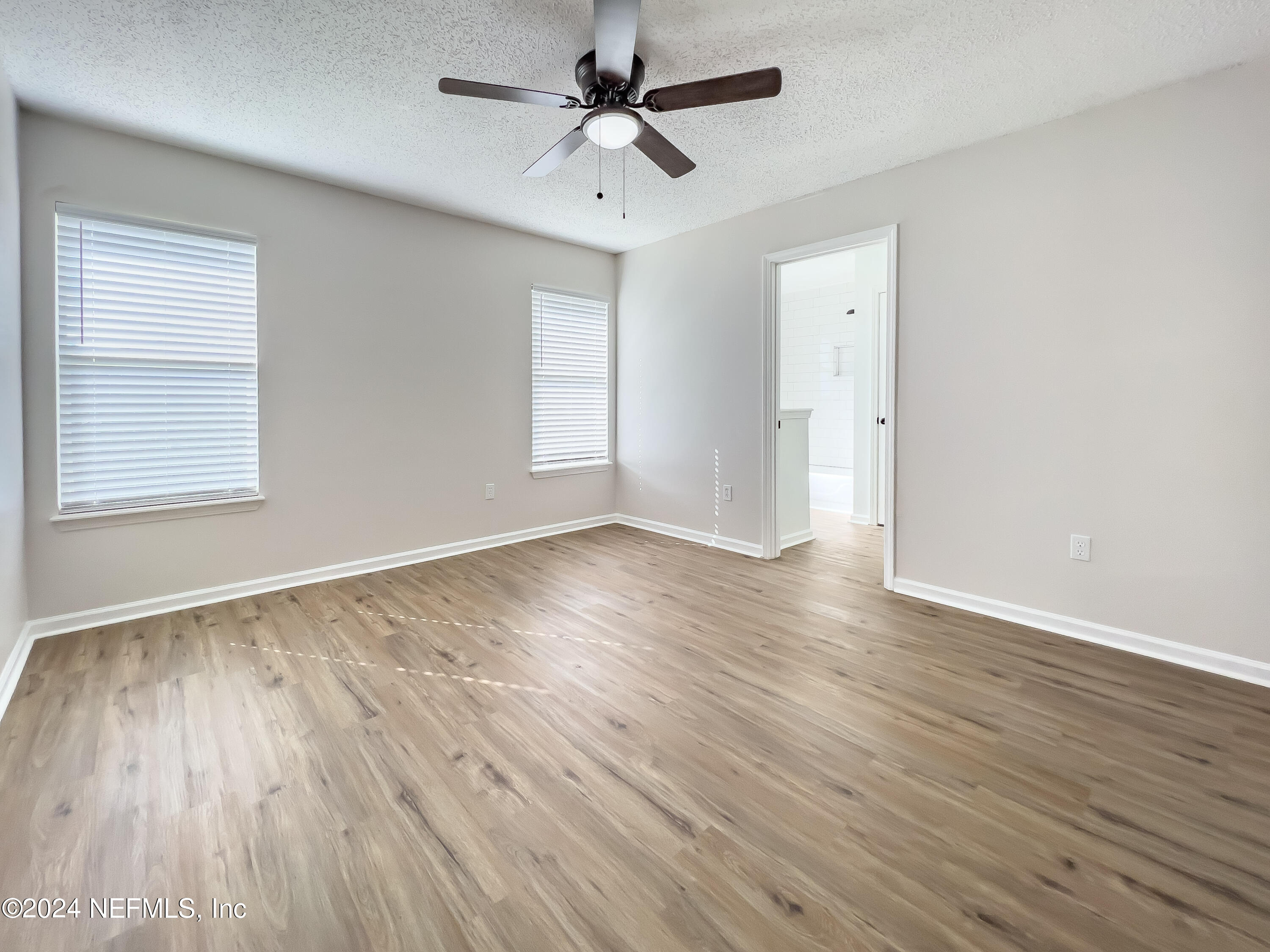 620 Morning Mist Way Orange Park, FL 32073 - Photo 18 of 34 an empty room with wooden floor ceiling fan and windows