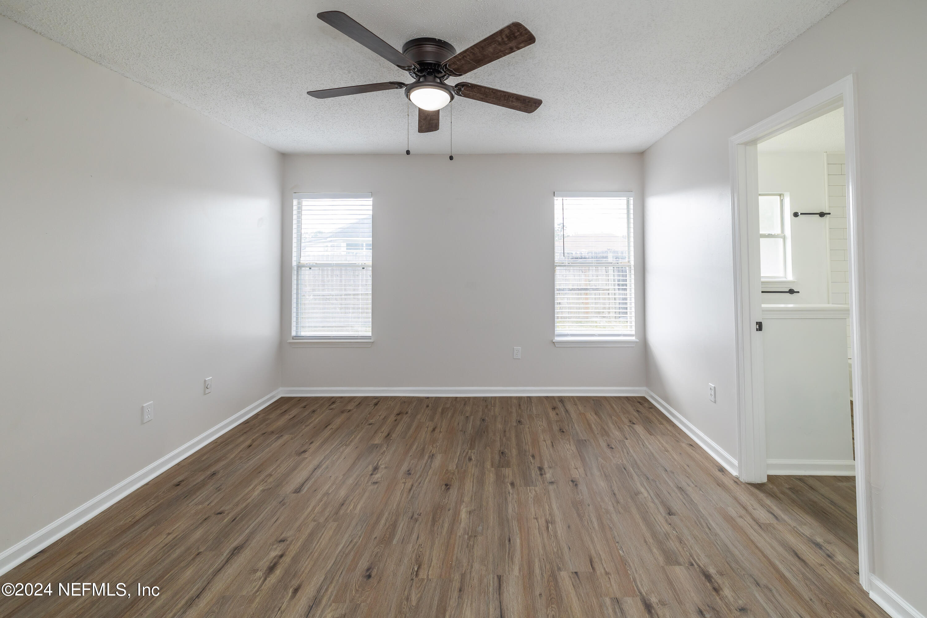 620 Morning Mist Way Orange Park, FL 32073 - Photo 20 of 34 an empty room with wooden floor ceiling fan and windows