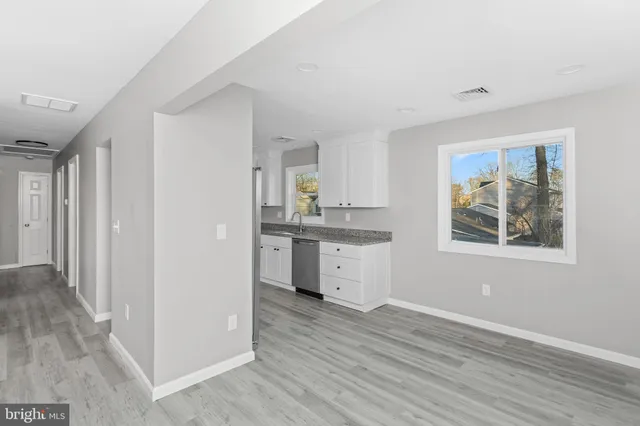 a view of a kitchen with wooden floor and a refrigerator