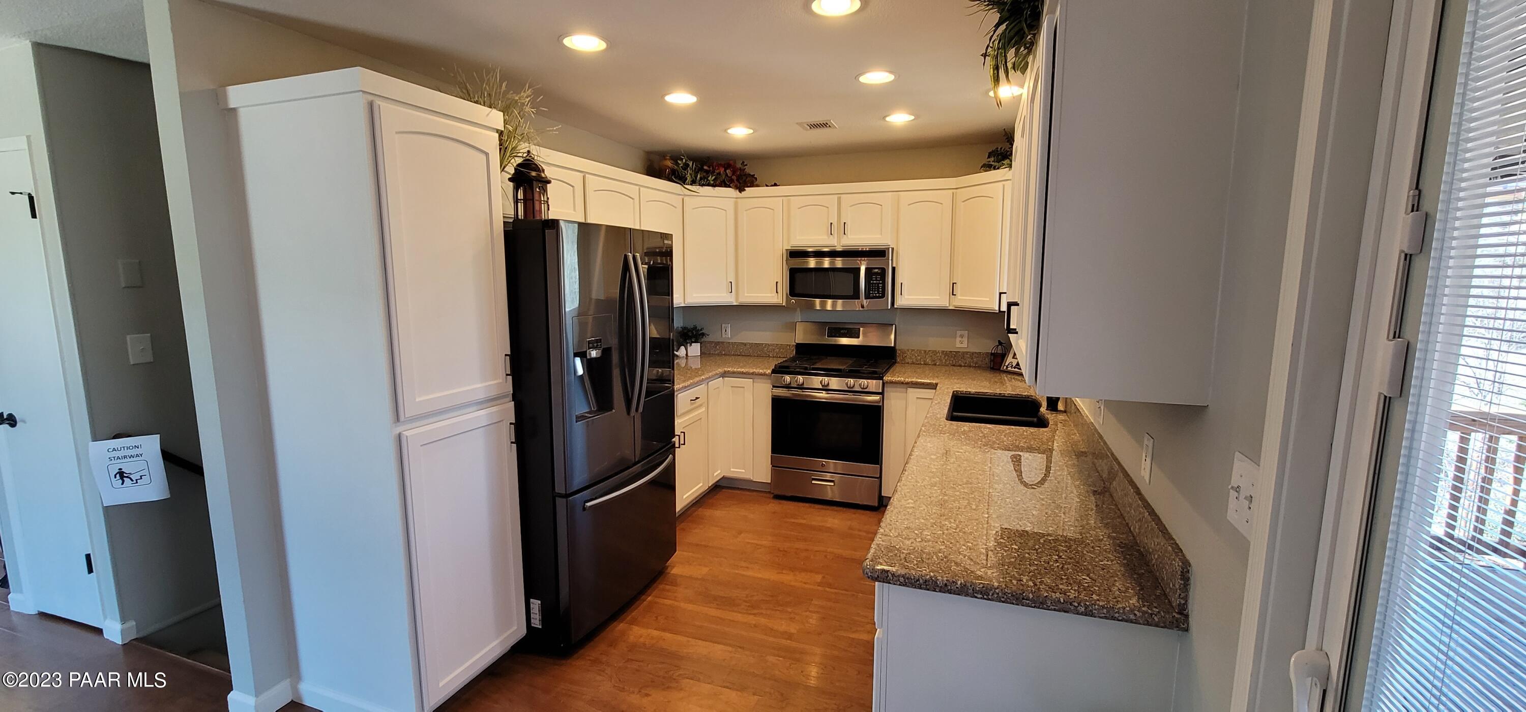 450 Valley Place Prescott, AZ 86301 - Photo 15 of 44 a kitchen with stainless steel appliances granite countertop a refrigerator a stove and a sink