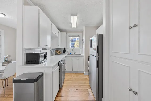 a kitchen with white cabinets and stainless steel appliances