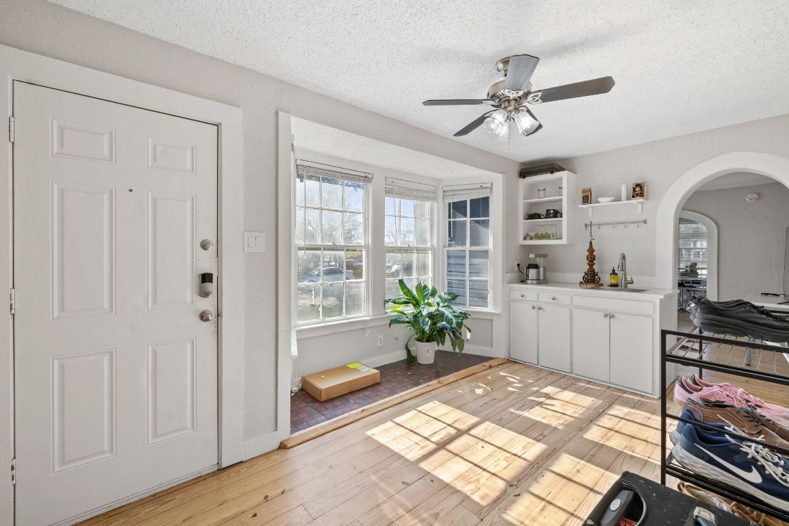 1202 East 29th Street, Unit A Austin, TX 78722 - Photo 15 of 37 Entryway with healthy amount of natural light, arched walkways, a ceiling fan, a textured ceiling, and light wood-style floors