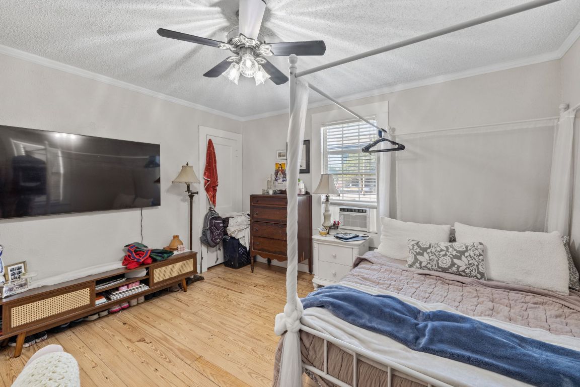 1202 East 29th Street, Unit A Austin, TX 78722 - Photo 22 of 37 Bedroom featuring light wood-style floors, a textured ceiling, crown molding, and ceiling fan