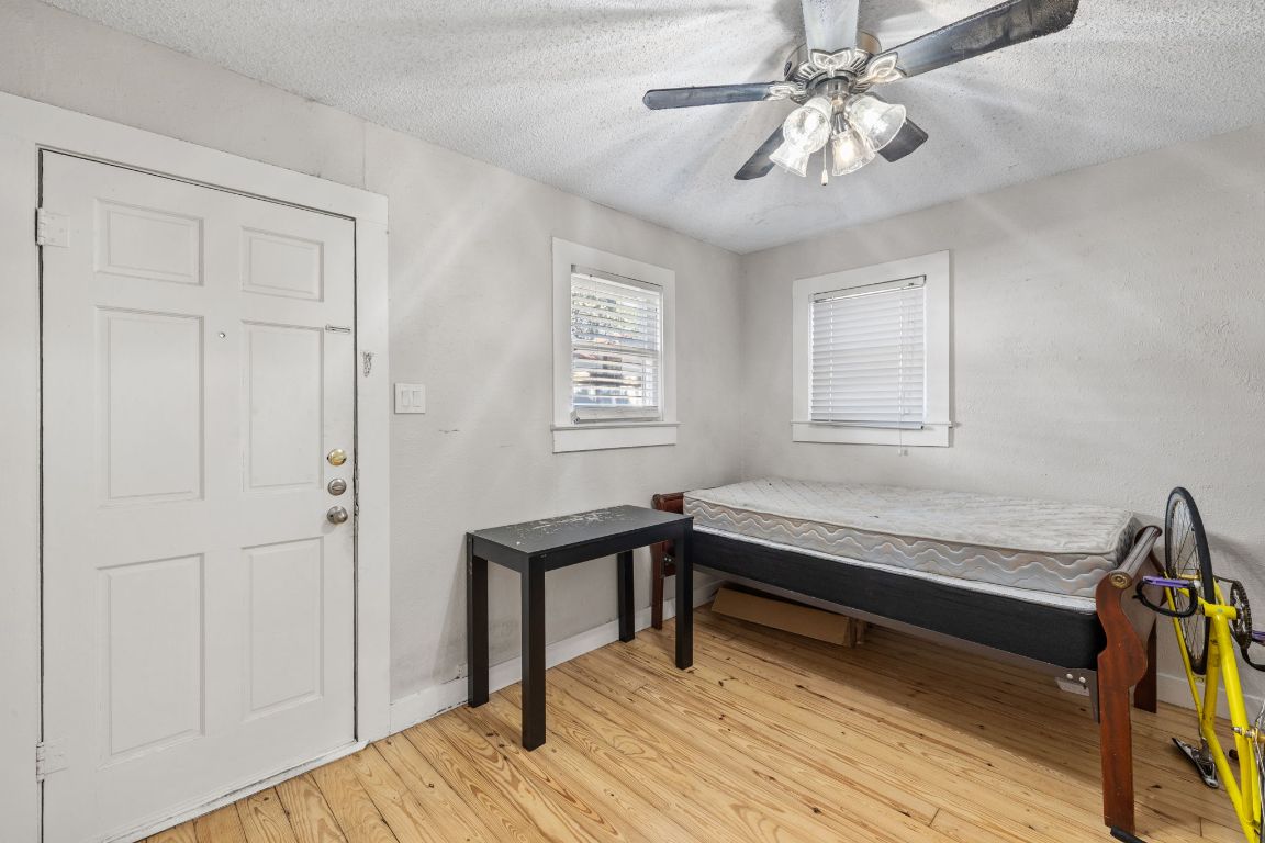 1202 East 29th Street, Unit A Austin, TX 78722 - Photo 23 of 37 Bedroom featuring a textured ceiling, a ceiling fan, and light wood finished floors