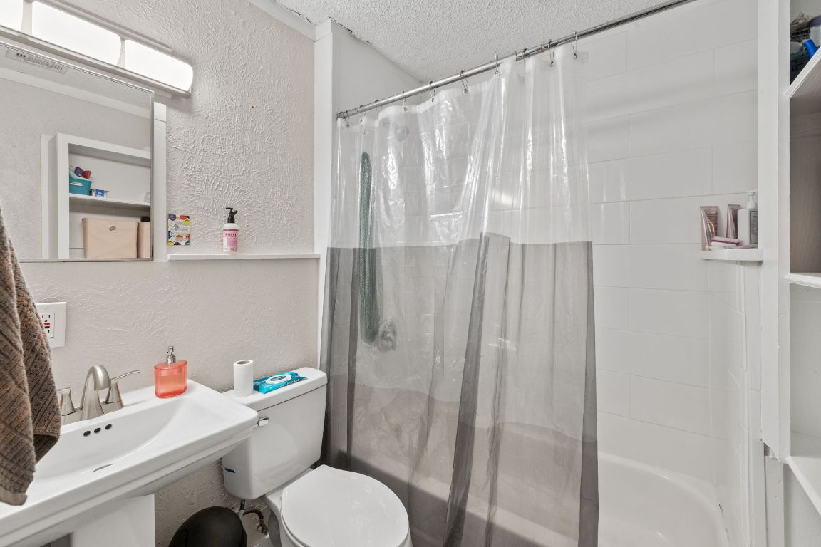 1202 East 29th Street, Unit A Austin, TX 78722 - Photo 27 of 37 Bathroom featuring a textured wall, a textured ceiling, and shower / bathtub combination with curtain