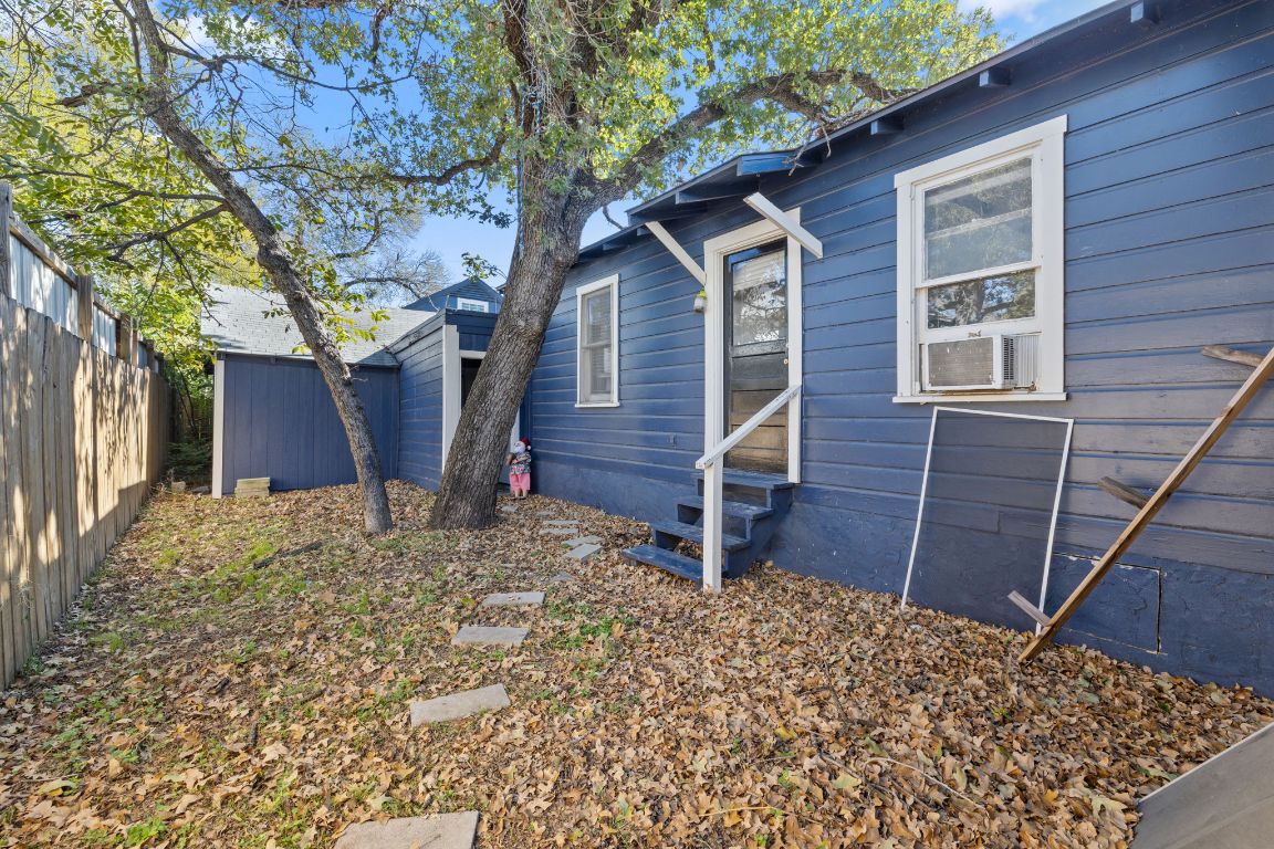 1202 East 29th Street, Unit A Austin, TX 78722 - Photo 32 of 37 View of side of home with entry steps, a fenced backyard, cooling unit, and an outbuilding