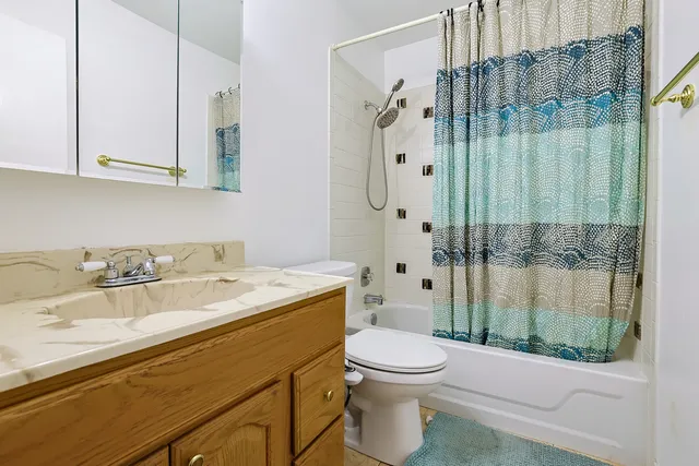 a bathroom with a granite countertop sink a toilet and shower