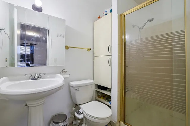 a bathroom with a sink a toilet and shower