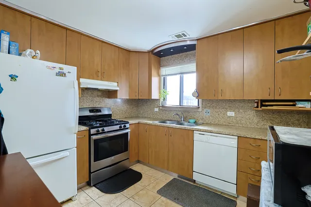 a kitchen with stainless steel appliances granite countertop a stove a sink and a refrigerator