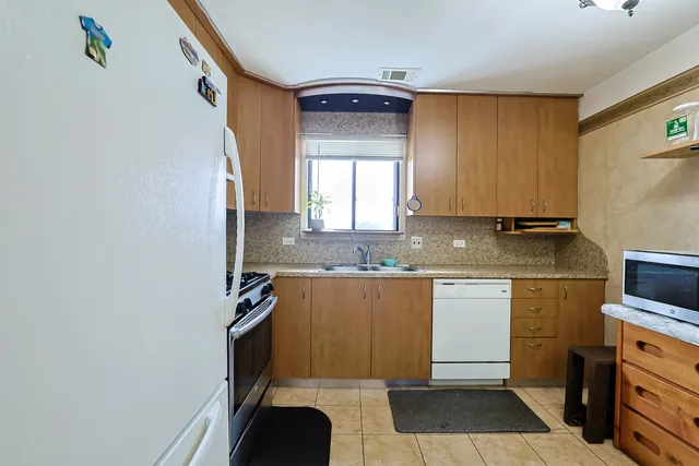 a kitchen with granite countertop cabinets stainless steel appliances a sink and a window