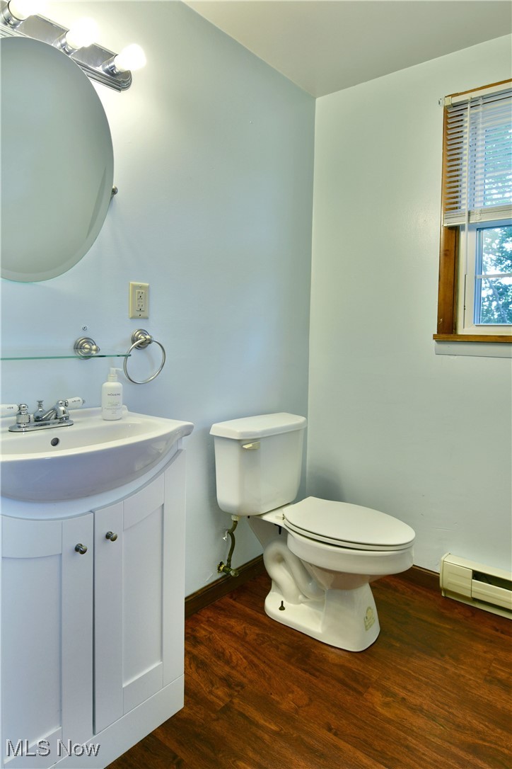 1141 Howell Road East Palestine, OH 44413 - Photo 37 of 41 Half bathroom with dark wood-style flooring, a baseboard radiator, and vanity