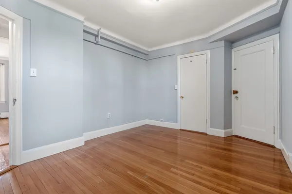 a view of an empty room with wooden floor