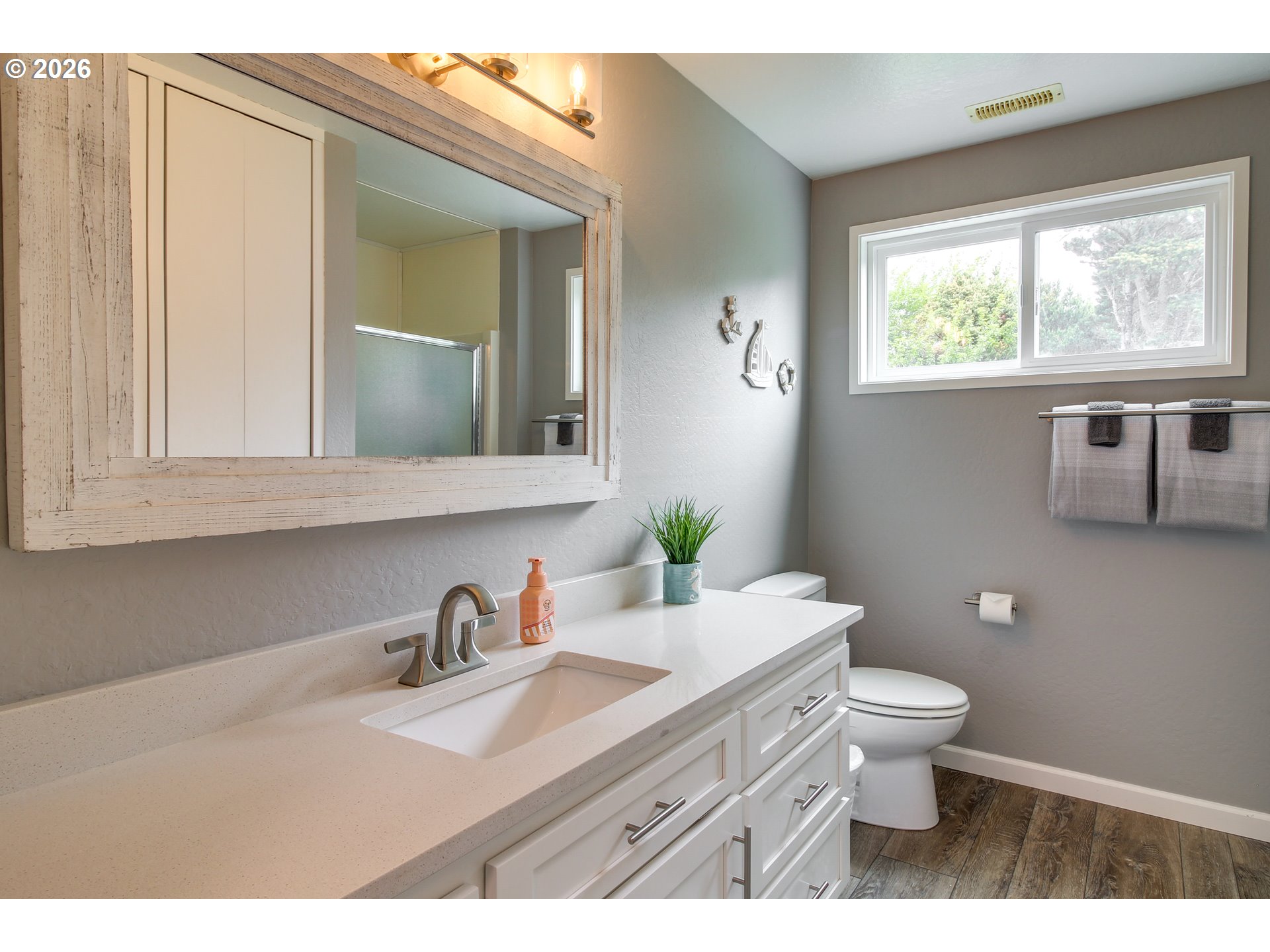 3085 Beach Loop Drive Southwest Bandon, OR 97411 - Photo 21 of 46 a bathroom with a granite countertop toilet sink and mirror