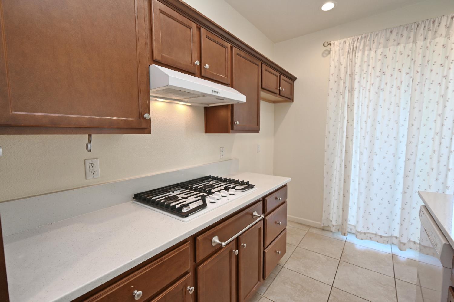 891 North Terra Cotta Drive Fresno, CA 93727 - Photo 12 of 32 a kitchen with cabinets and a stove top oven