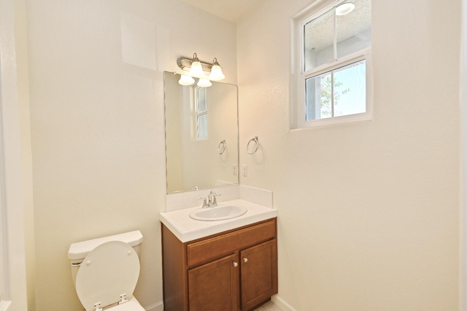 891 North Terra Cotta Drive Fresno, CA 93727 - Photo 18 of 32 a bathroom with a toilet sink and mirror