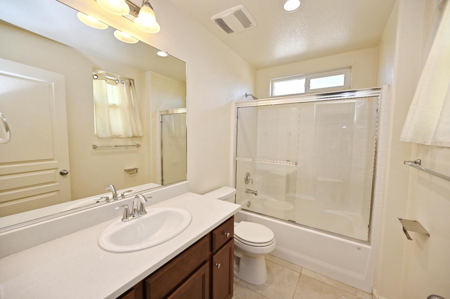 891 North Terra Cotta Drive Fresno, CA 93727 - Photo 22 of 32 a bathroom with a sink toilet a mirror and shower