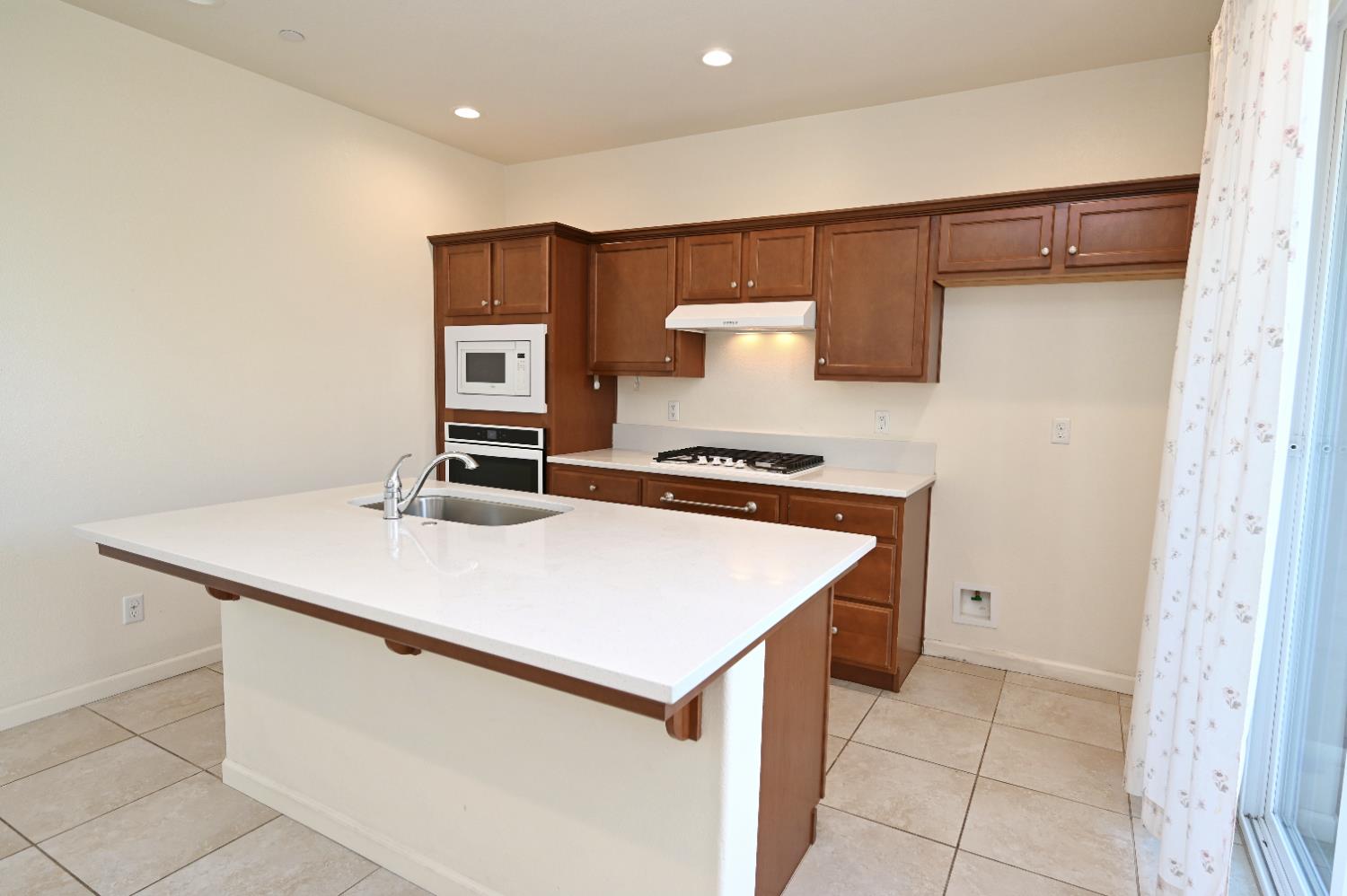 891 North Terra Cotta Drive Fresno, CA 93727 - Photo 7 of 32 a kitchen with a stove and a refrigerator