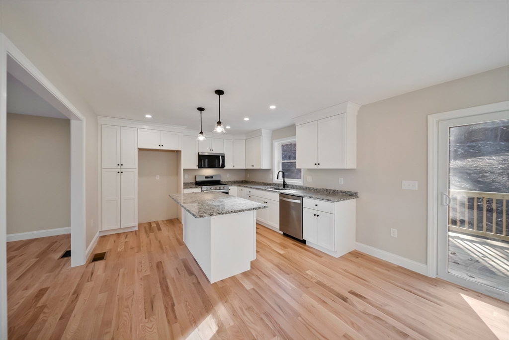 53 Kimball Hill Road, Unit A Hudson, NH 03051 - Photo 7 of 41 a kitchen with stainless steel appliances a white stove top oven and white walls