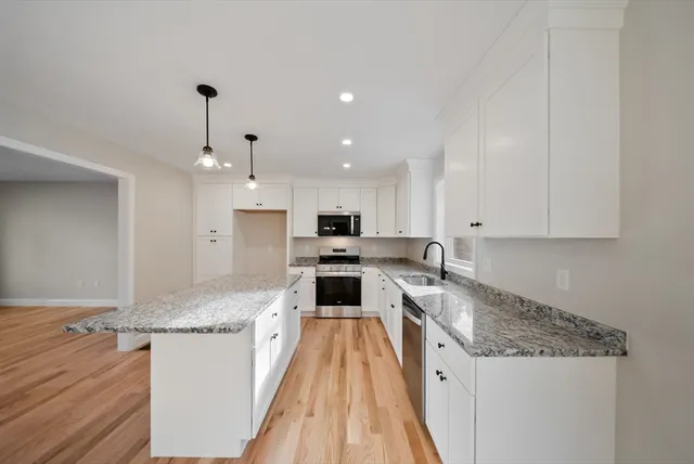 a large kitchen with stainless steel appliances granite countertop a stove a sink and a refrigerator