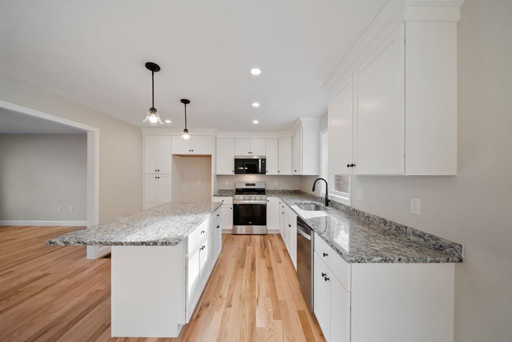 53 Kimball Hill Road, Unit A Hudson, NH 03051 - Photo 8 of 41 a large kitchen with stainless steel appliances granite countertop a stove a sink and a refrigerator