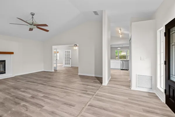 a view of empty room with wooden floor and window