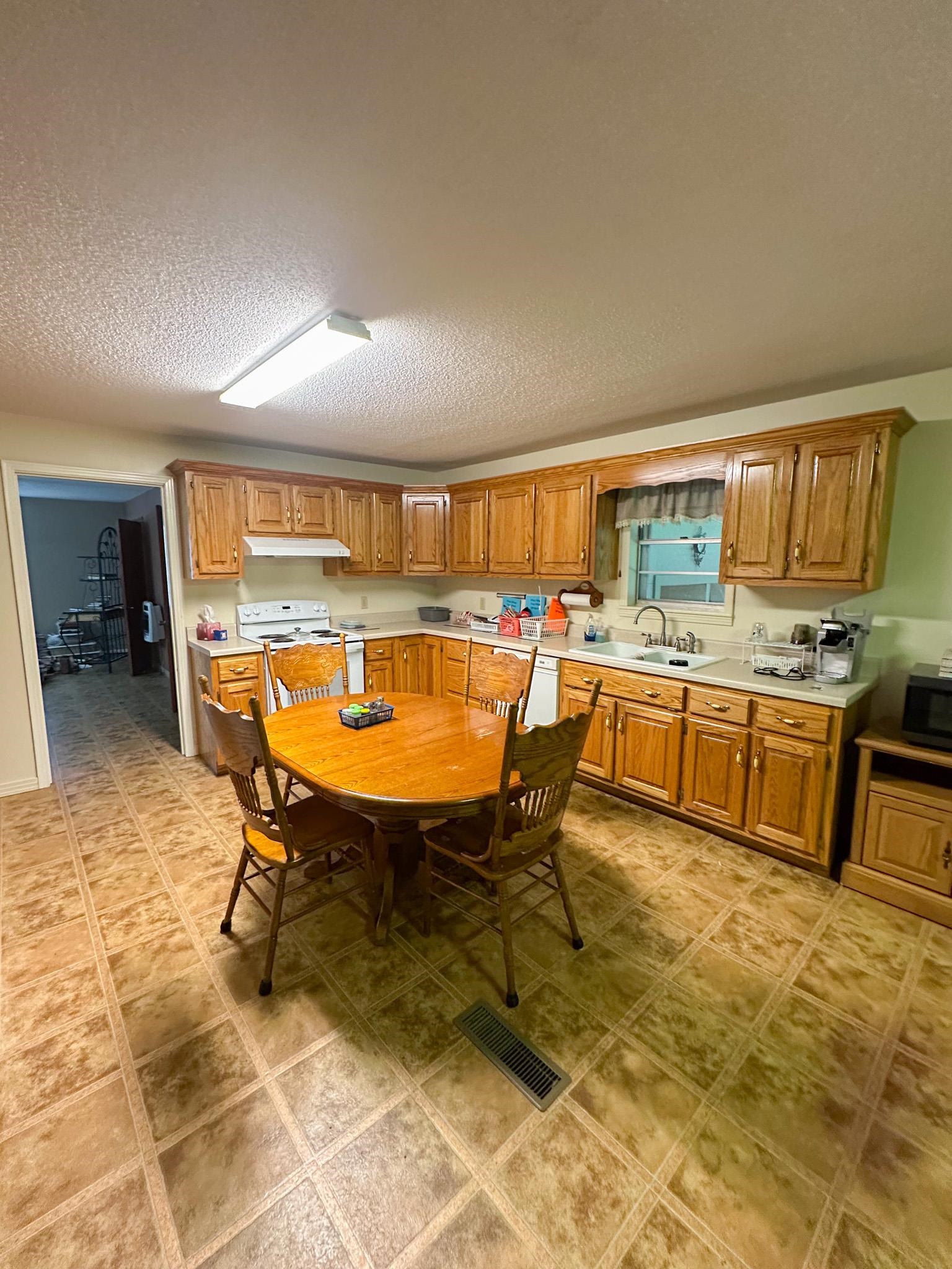 1630 Pleasant Hill Road Iuka, MS 38852 - Photo 5 of 14 a view of a kitchen with kitchen island dining table and chair