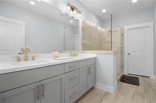 a bathroom with a double vanity sink a mirror and a shower