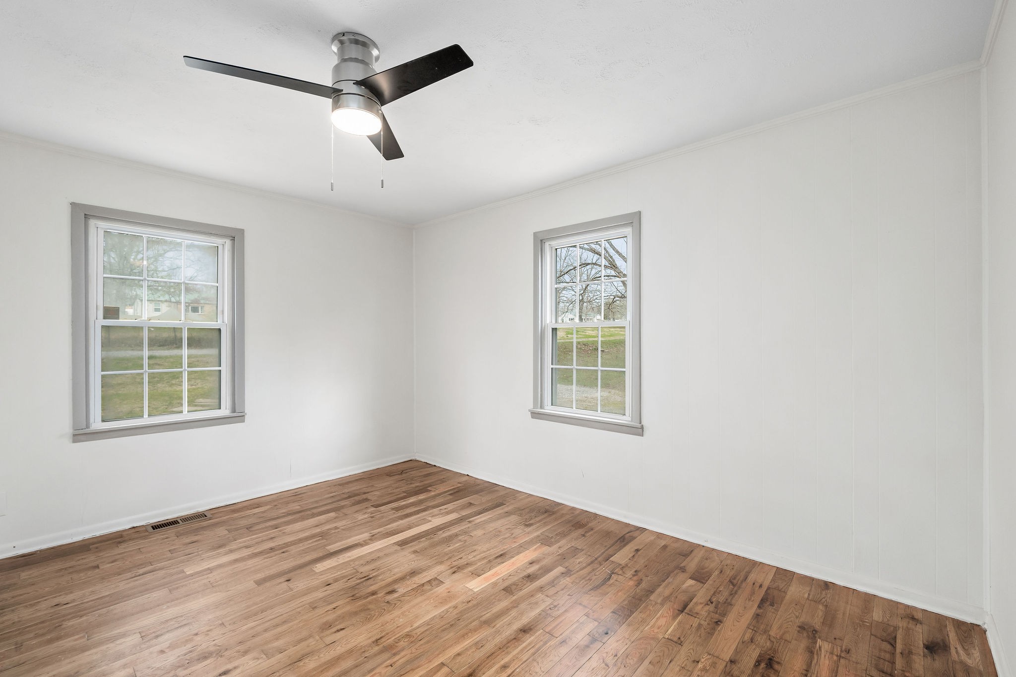 8626 Bockman Way Sparta, TN 38583 - Photo 19 of 25 an empty room with wooden floor ceiling fan and windows