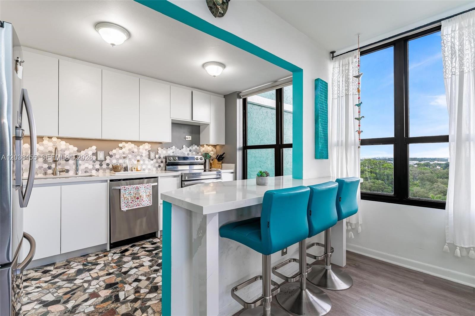 780 Northeast 69th Street, Unit 1010 Miami, FL 33138 - Photo 13 of 31 a kitchen with stainless steel appliances kitchen island granite countertop a refrigerator a sink a stove and white cabinets with wooden floor