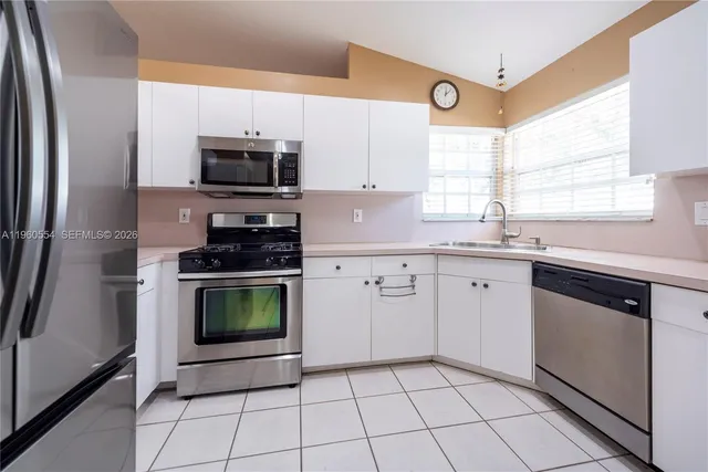 a kitchen with a sink window and cabinets