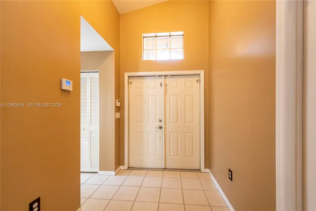 a view of a hallway with wooden floor and a bathroom