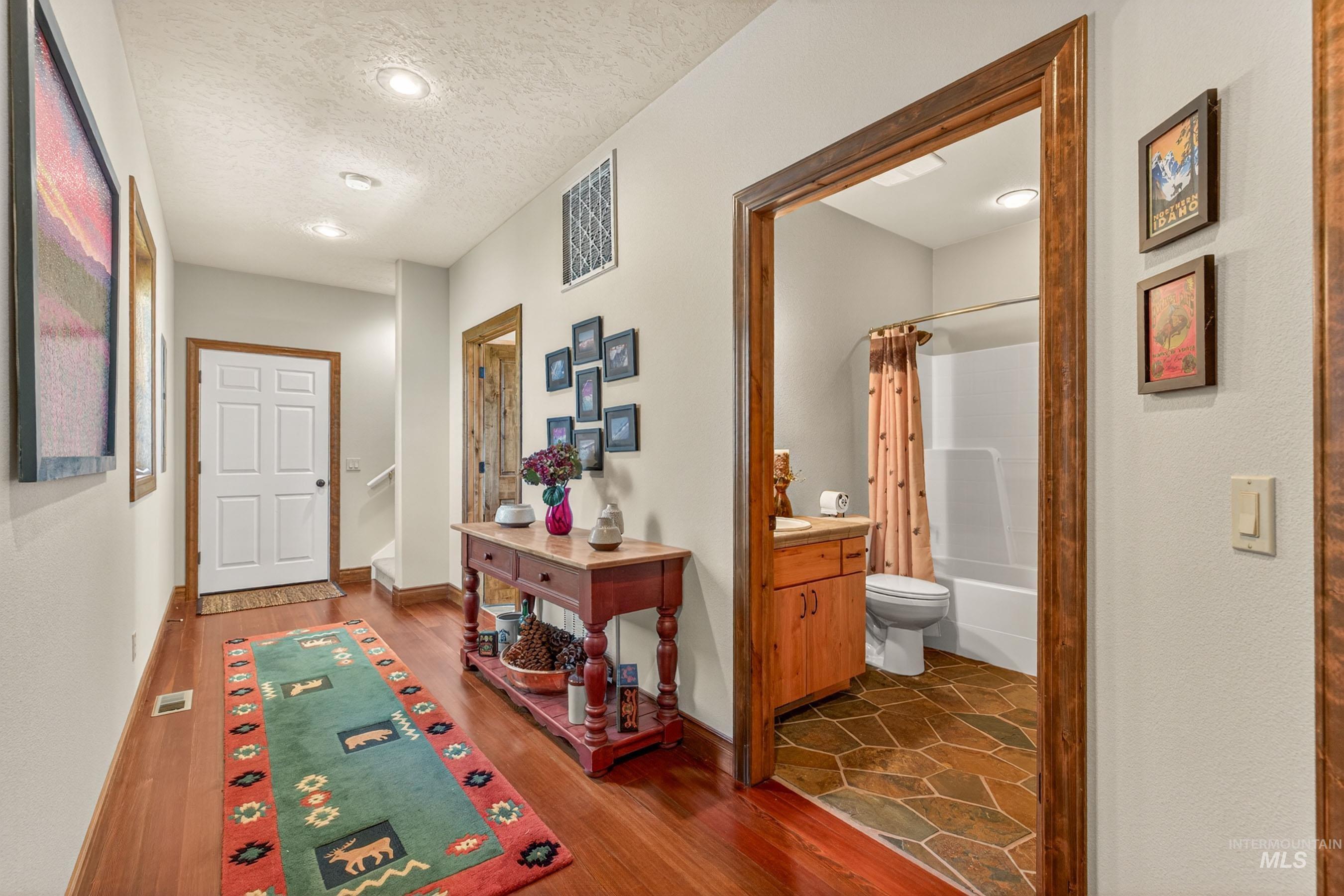 113 Deford Road White Bird, ID 83554 - Photo 22 of 49 Hallway featuring wood-finish flooring, recessed lighting, and a white six-panel door