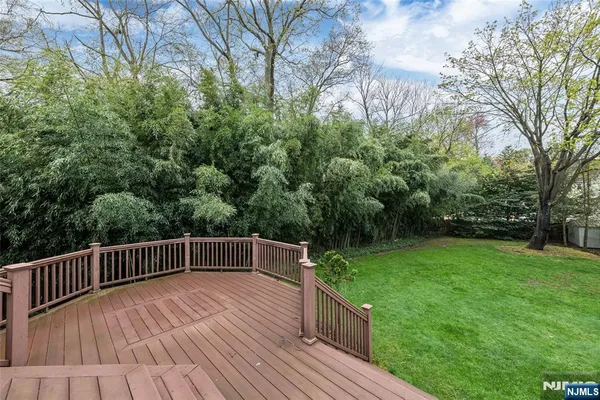 a view of backyard with deck and trees