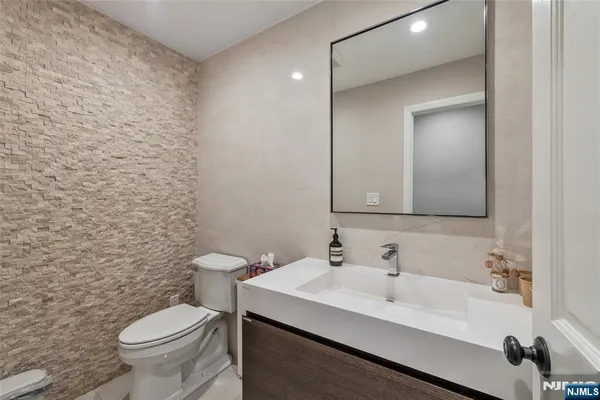a bathroom with a sink a toilet and a mirror