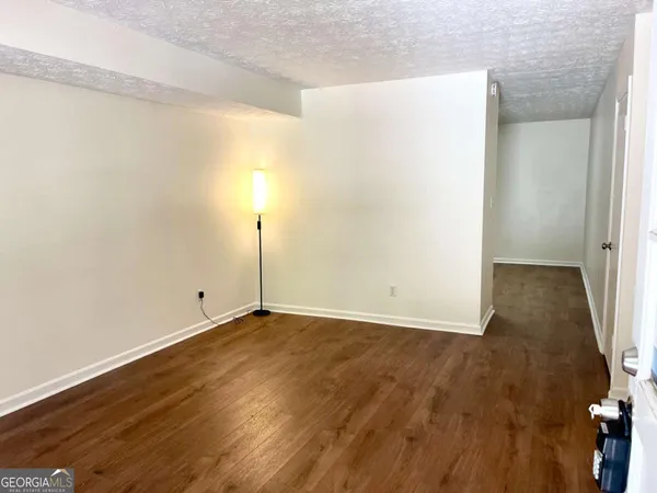 a view of an empty room with wooden floor