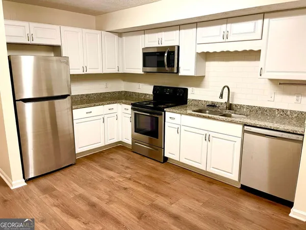 a kitchen with stainless steel appliances granite countertop a refrigerator sink and stove