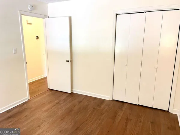 a view of an empty room with wooden floor